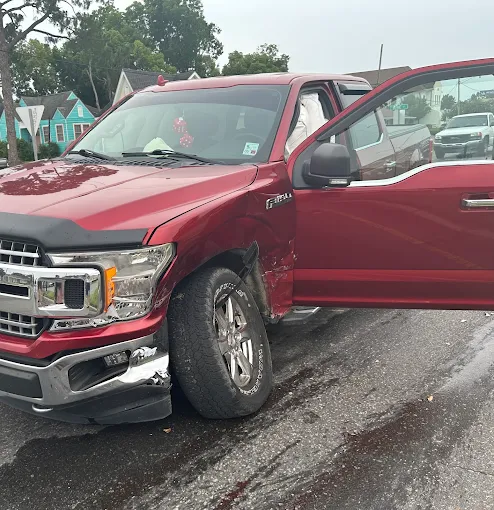 Damaged red Ford F-150 before repair